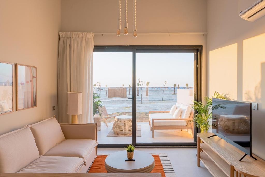 a living room with a couch and a tv at Lemon Spaces LIGHT- D bay North Coast in Zāwiyat ‘Abd al Mun‘im