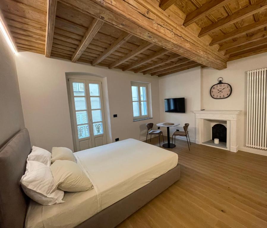 a bedroom with a large bed and a fireplace at La Dimora del Brocante in Cuneo
