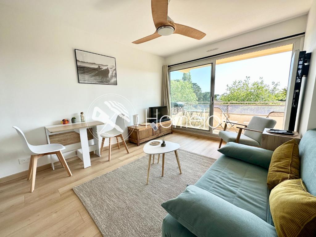 un soggiorno con divano e tavolo di T2 refait à neuf – À 2 pas du bourg et des plages a Larmor-Plage