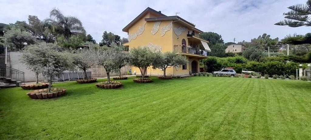 ein Haus mit großem Rasen davor in der Unterkunft Casa Maremonti vicino Cefalu in Campofelice di Roccella