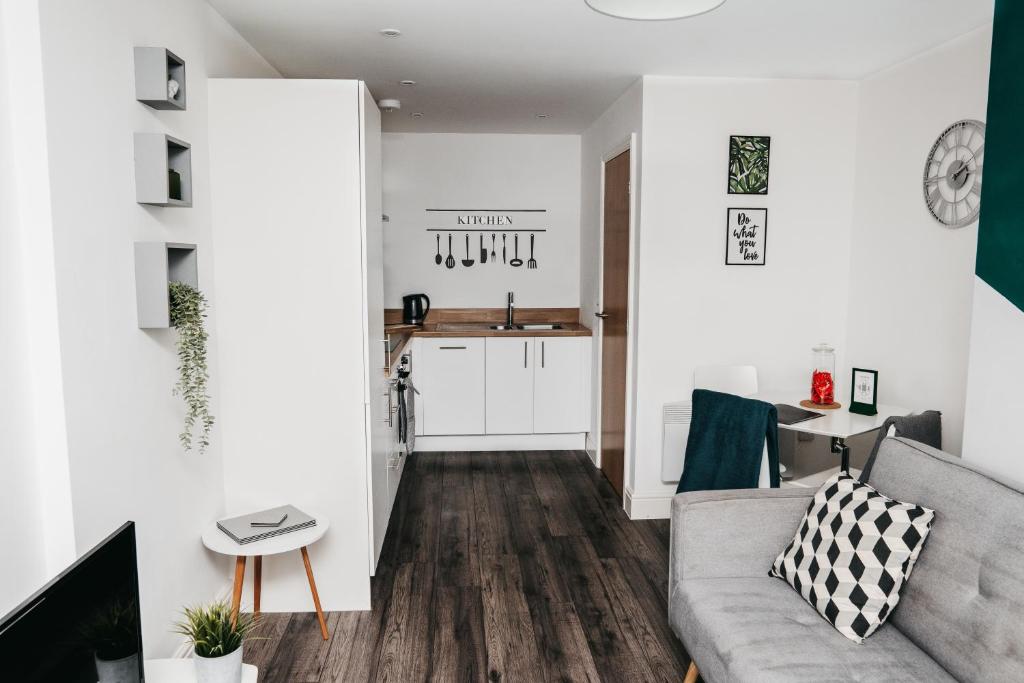 a living room with a couch and a kitchen at Modern Centre of the city 1 bedroom apartment in Sheffield