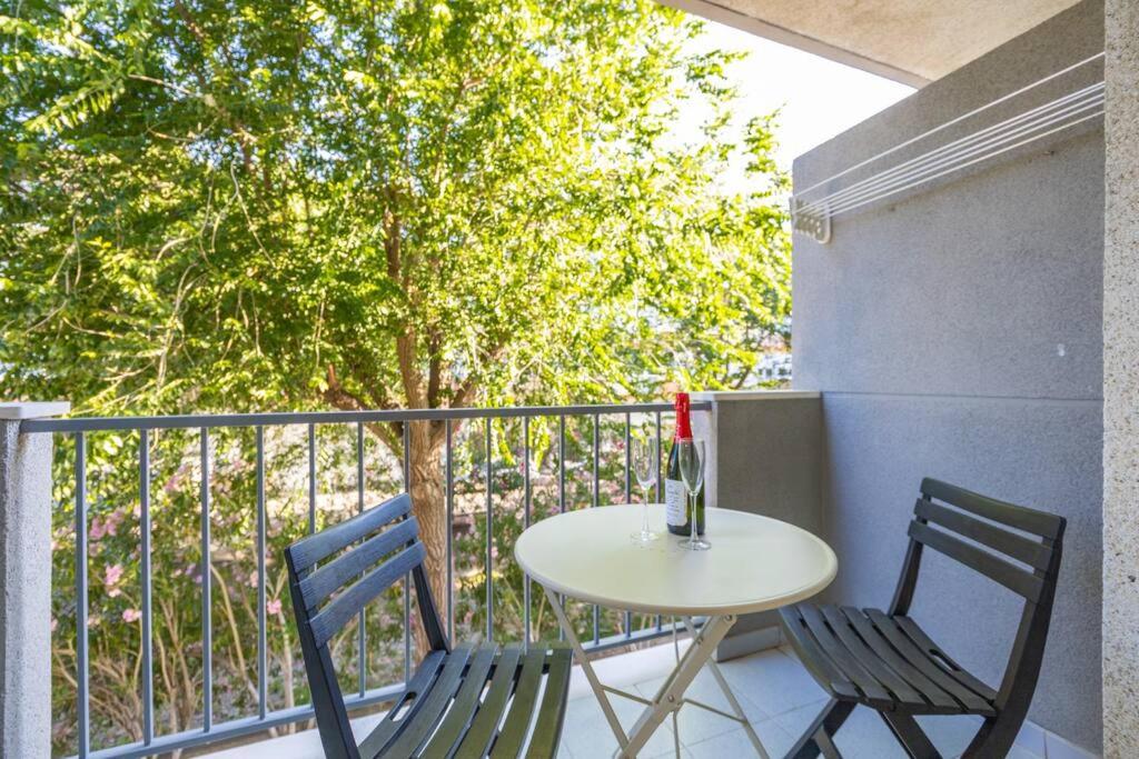 una mesa con 2 sillas y una botella de vino en el balcón en La Cuana, en Roses