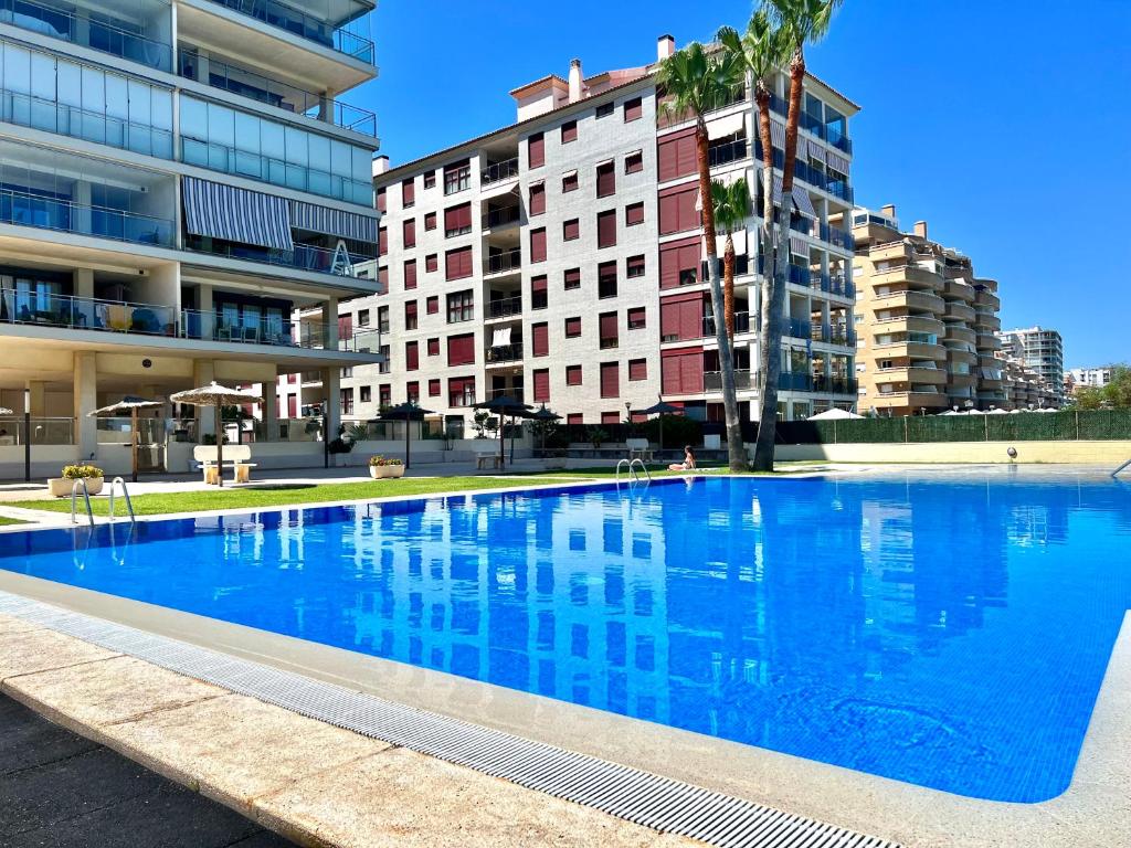 a large blue swimming pool in front of some buildings at Apartamentos Boutique Terrazas in Oropesa del Mar