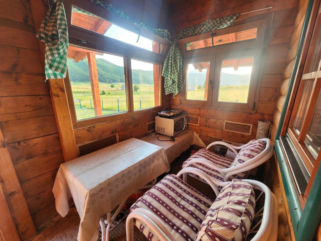 een kamer met drie bedden en een tv. bij Planinska tišina Guest House in Pluzine