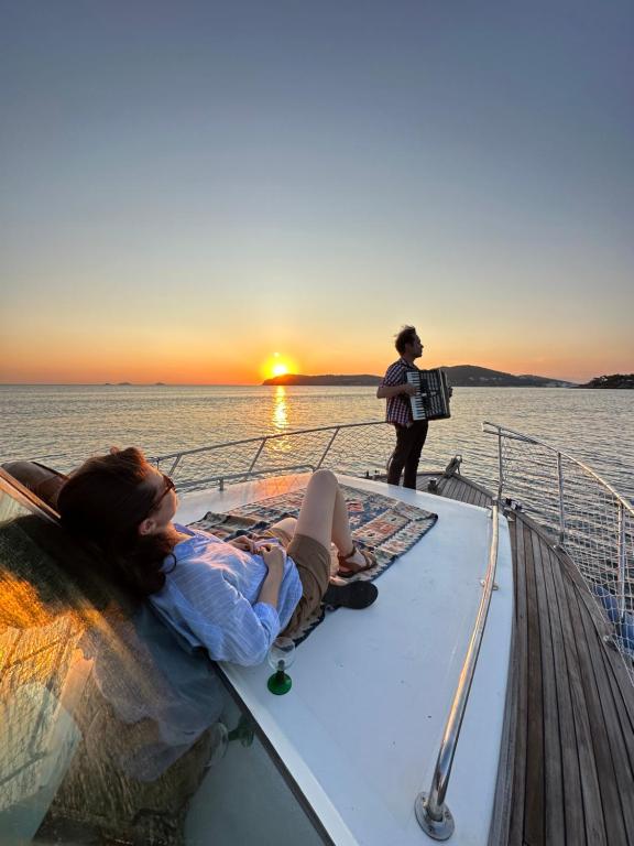 a woman laying on the deck of a boat at sunset at Lovely Lobster in the Island in Adalar