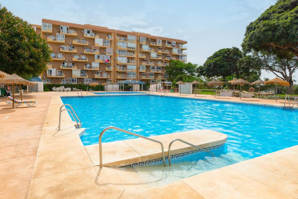 a large swimming pool in front of a hotel at Apartamento vistas a piscina in Benalmádena