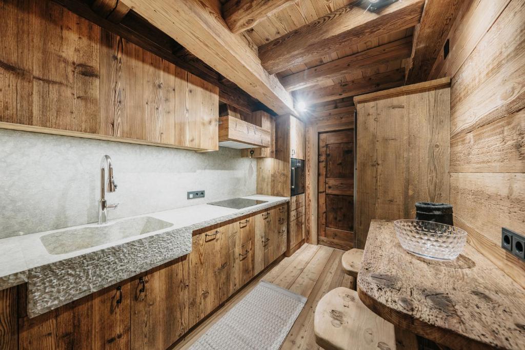 a kitchen with wooden cabinets and a sink at Luxury Cortina in Cortina dʼAmpezzo