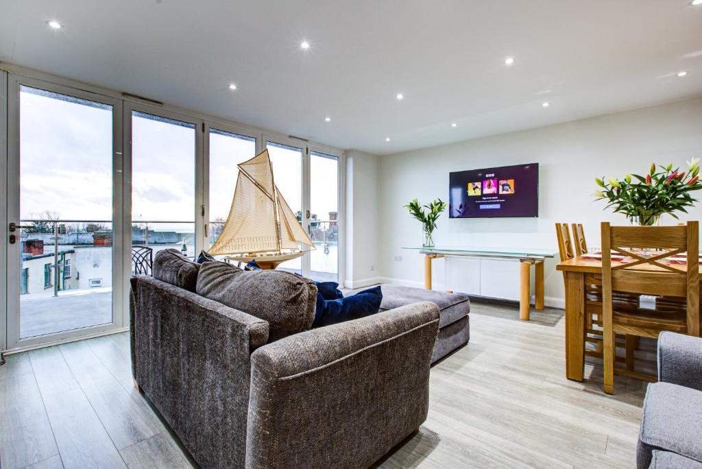 a living room with two couches and a table and a dining room at leigh Penthouse Apartment in Leigh-on-Sea