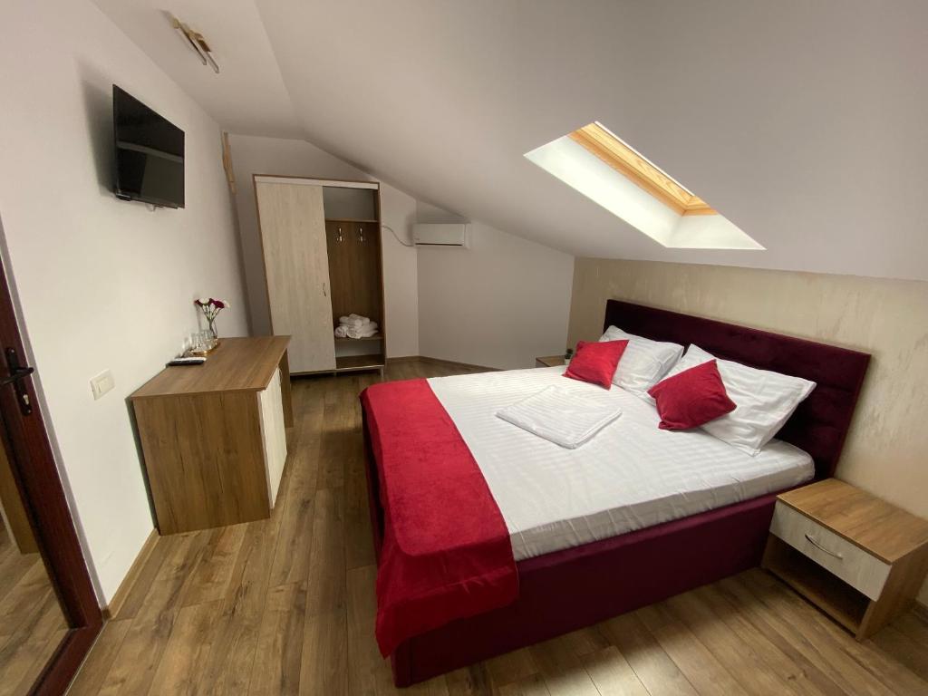 una camera da letto con un grande letto con lenzuola rosse e bianche di Vila Marisa a Eforie Nord