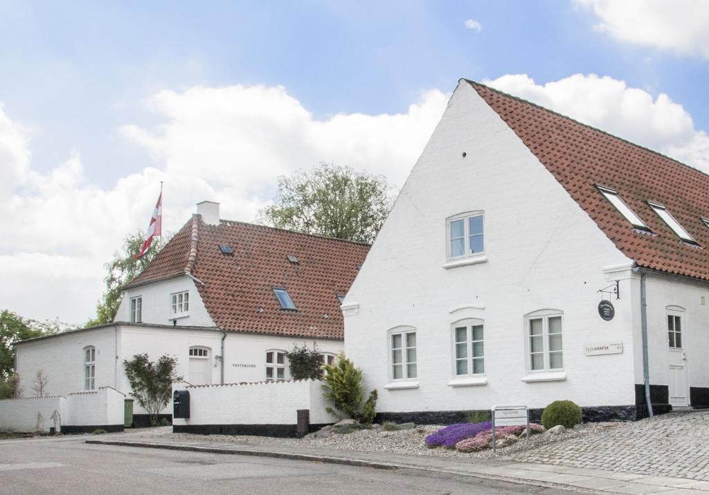 Casa blanca con techo rojo en Skovridergaardens Ferielejligheder en Åbenrå