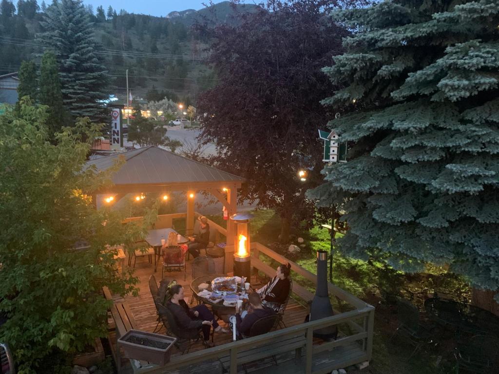 een groep mensen die 's nachts aan een tafel in een tuin zitten bij Destination INN in Radium Hot Springs