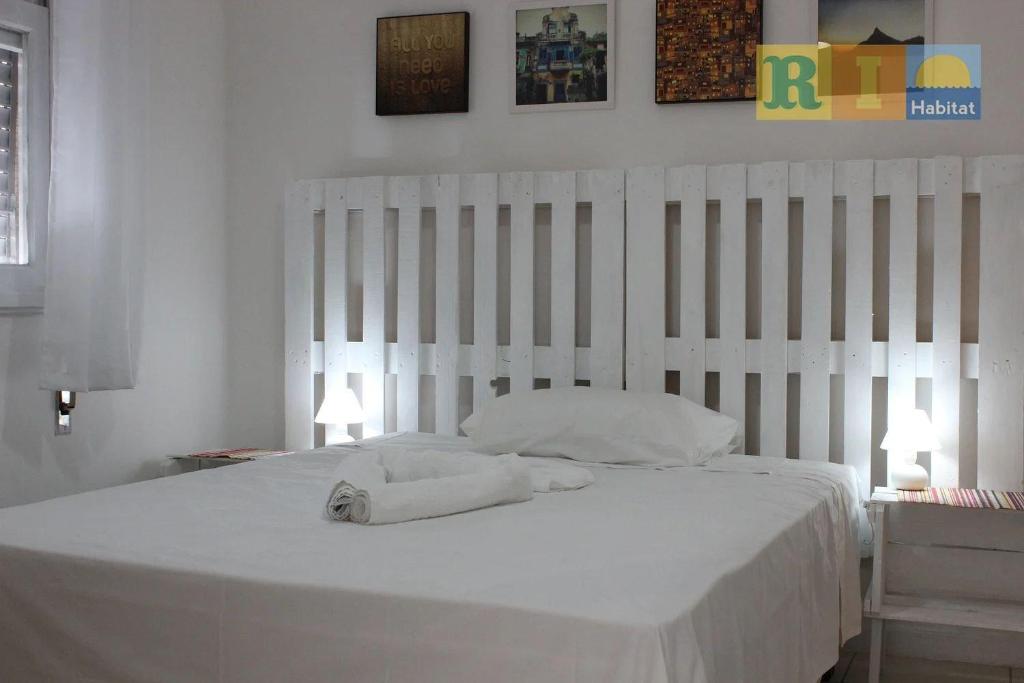 1 dormitorio con 1 cama blanca y 2 toallas en Rio Habitat Weaver, en Río de Janeiro