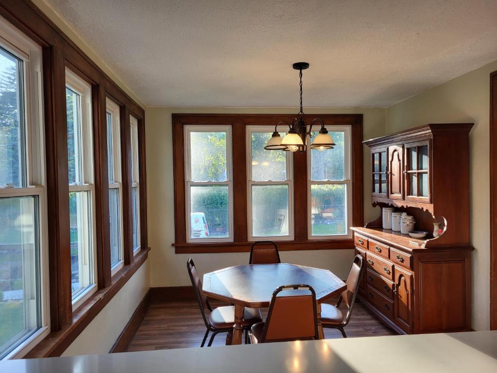 - une salle à manger avec une table, des chaises et des fenêtres dans l'établissement Seabreeze Three Bedroom Home, à Rochester