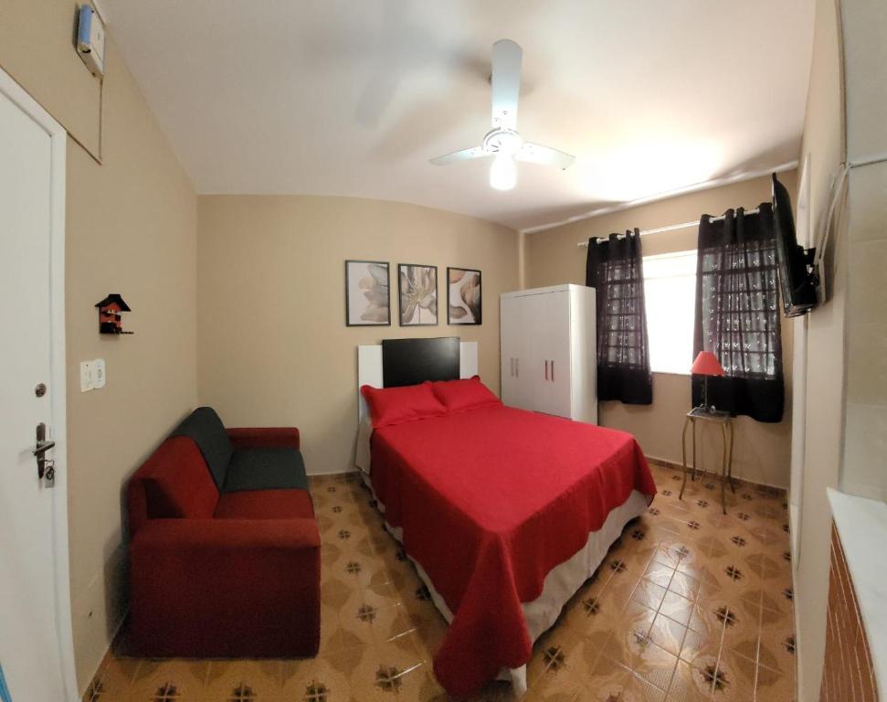 a bedroom with a red bed and a chair at Apartamento em São Lourenço-mg in São Lourenço