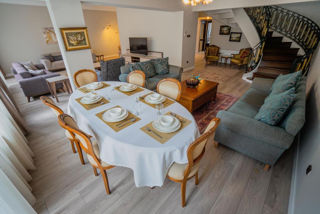 Verula City Apartments في طرابزون: غرفة طعام مع طاولة بيضاء وكراسي