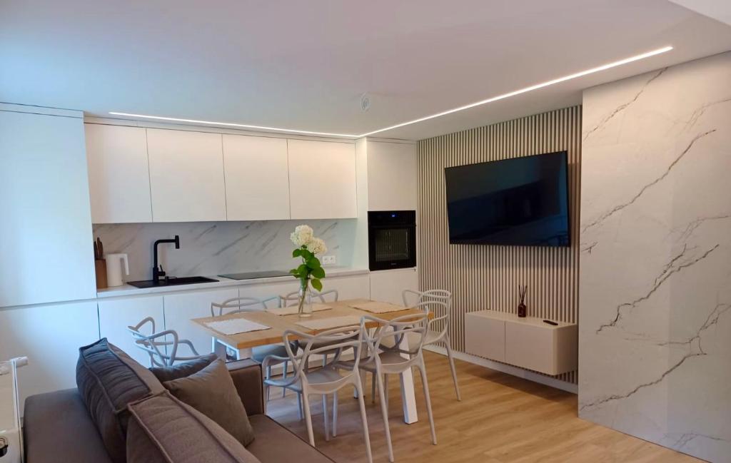 a kitchen and living room with a table and a couch at Apartament Gościnny Zakątek in Sumowo