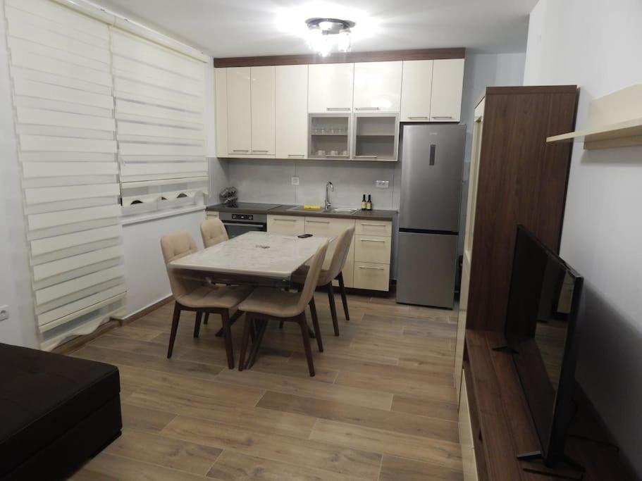 een keuken met een tafel en stoelen en een koelkast bij Zvezda vodilja 2 in Veternik