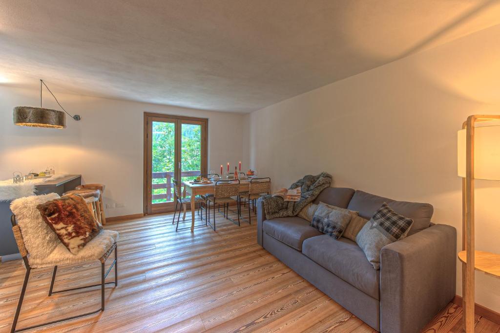 ein Wohnzimmer mit einem Sofa und einem Tisch in der Unterkunft Casa Joelle in Courmayeur