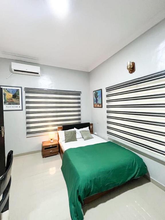 Un dormitorio con una cama con una manta verde. en Glides suite by Home Glides, en Lekki