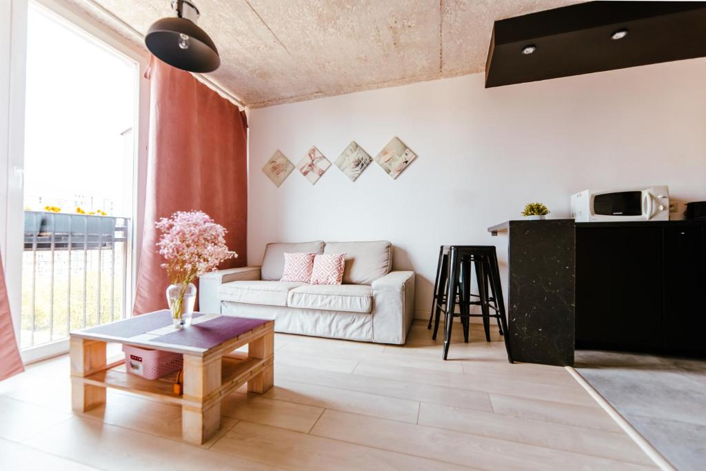 a living room with a white couch and a table at Industrial 9th Floor Central Apartment with Balcony and Views in Warsaw