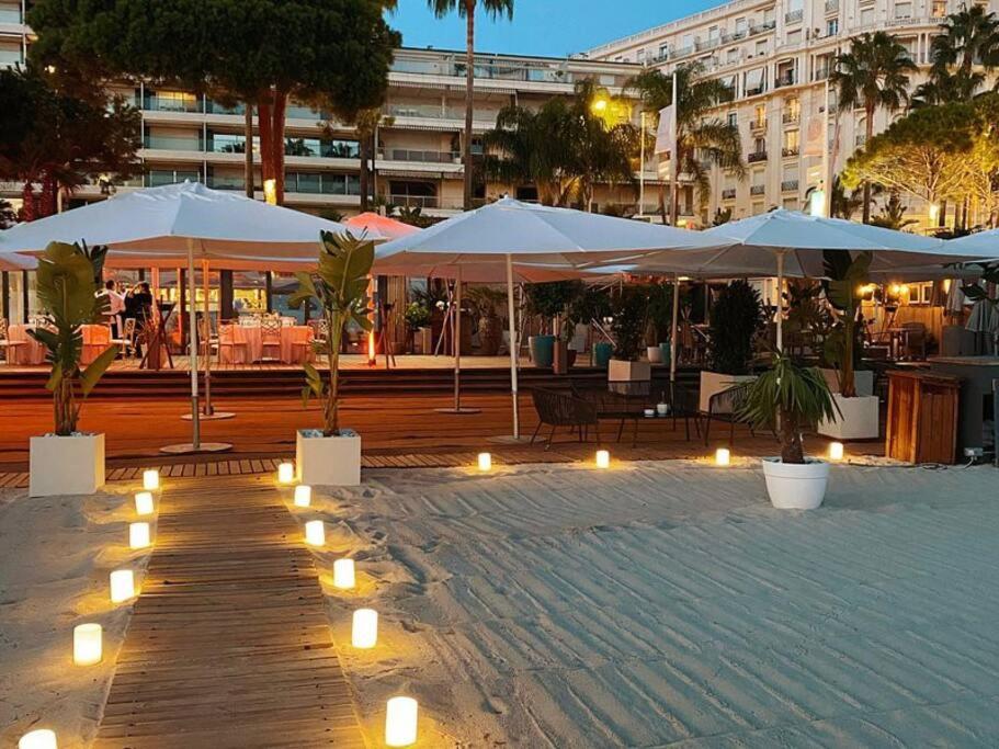 a patio with umbrellas and lights in a city at Palais Miramar - Suite White Jardin - 20m Plage in Cannes