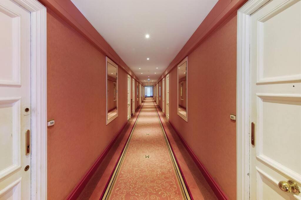 a hallway with orange walls and a long hallway at Palais Miramar - Suite White Jardin - 20m Plage in Cannes