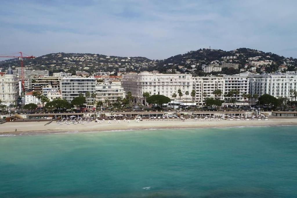 a view of a beach with buildings and the ocean at Palais Miramar - Suite White Jardin - 20m Plage in Cannes