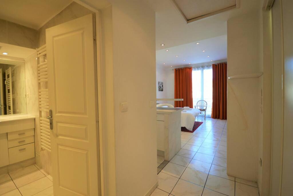 a bathroom with a door leading to a bedroom at Palais Miramar - Suite White Jardin - 20m Plage in Cannes
