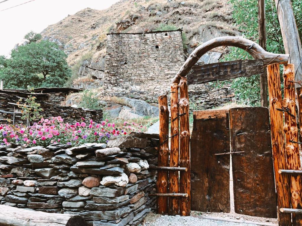 uma velha porta de madeira e uma parede de pedra em Ethnic Hostel Shatili em Shatili