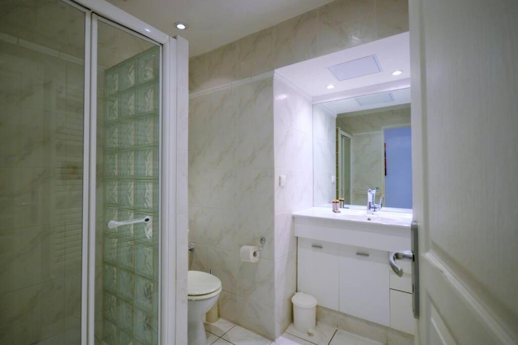 a bathroom with a toilet and a sink and a shower at Palais Miramar - Suite White Jardin - 20m Plage in Cannes