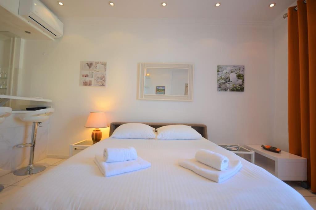 a bedroom with a white bed with two white towels on it at Palais Miramar - Suite White Jardin - 20m Plage in Cannes