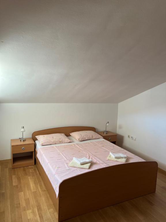 um quarto com uma cama grande e 2 mesas de cabeceira em Apartmani Iva em Biograd na Moru