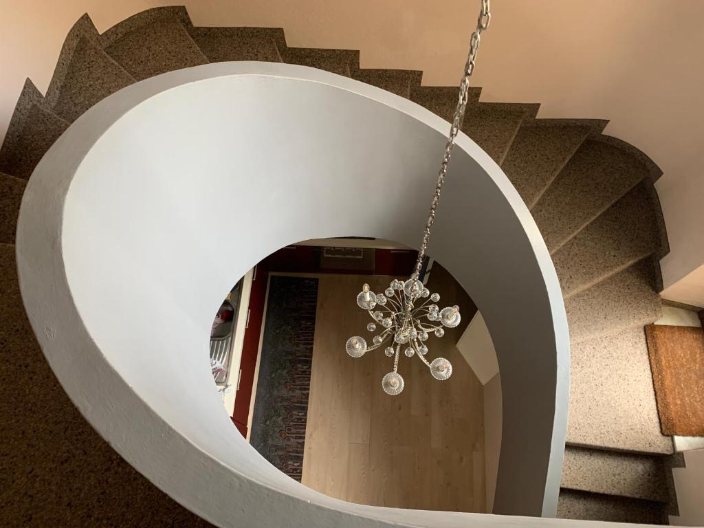 Una escalera circular con una lámpara de araña en un edificio en Casa Cervo, en Olbia