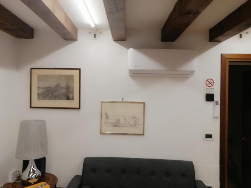 ein Wohnzimmer mit Sofa und Bildern an der Wand in der Unterkunft Fiore della Laguna in Venedig