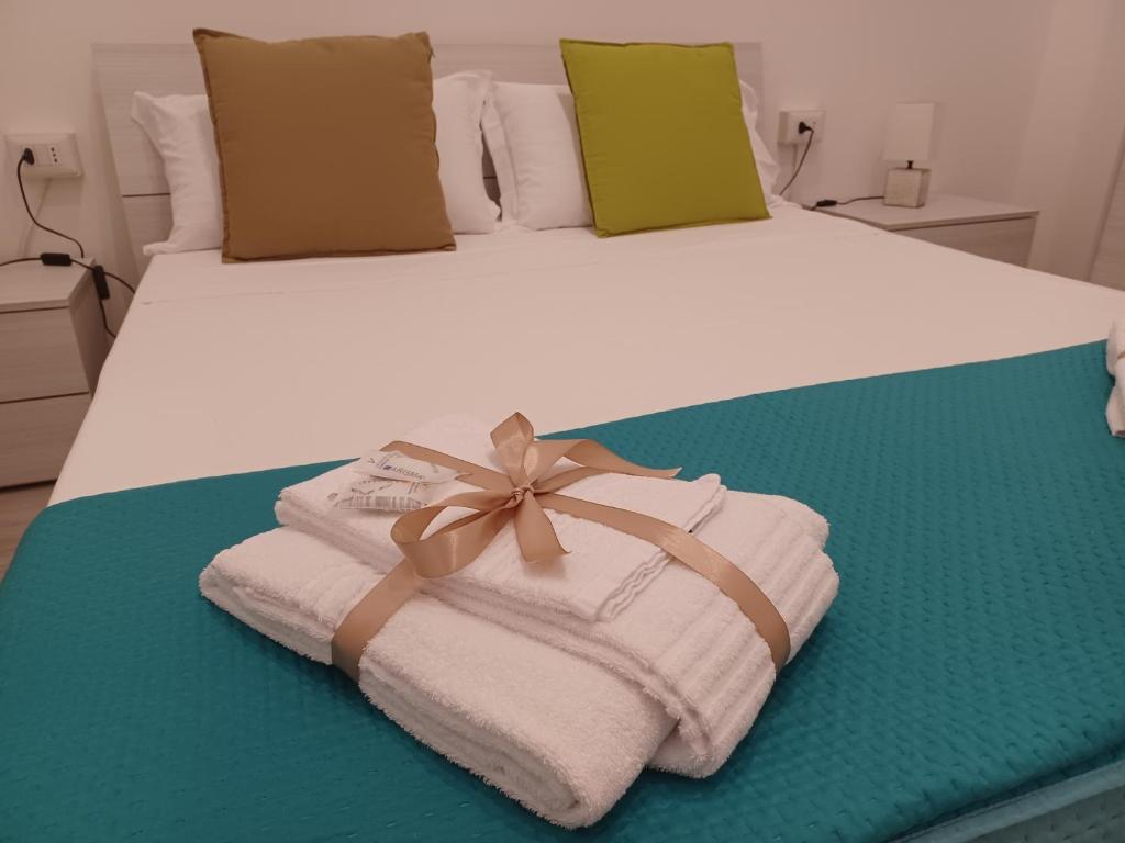 Una cama con toallas y un arco. en Il cuore della Puglia, en Palagiano