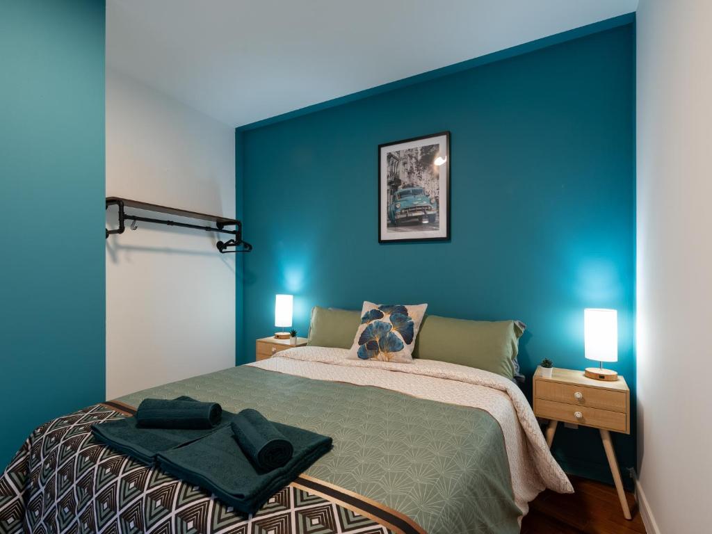 ヴィルールバンヌにあるLE PHENIX - HYPERCENTRE 16 PERSONNES GARAGE GRATUIT WiFi JARDIN BARBECUE PROCHE PARC TETE D'ORの青いベッドルーム(ベッド1台、ランプ2つ付)