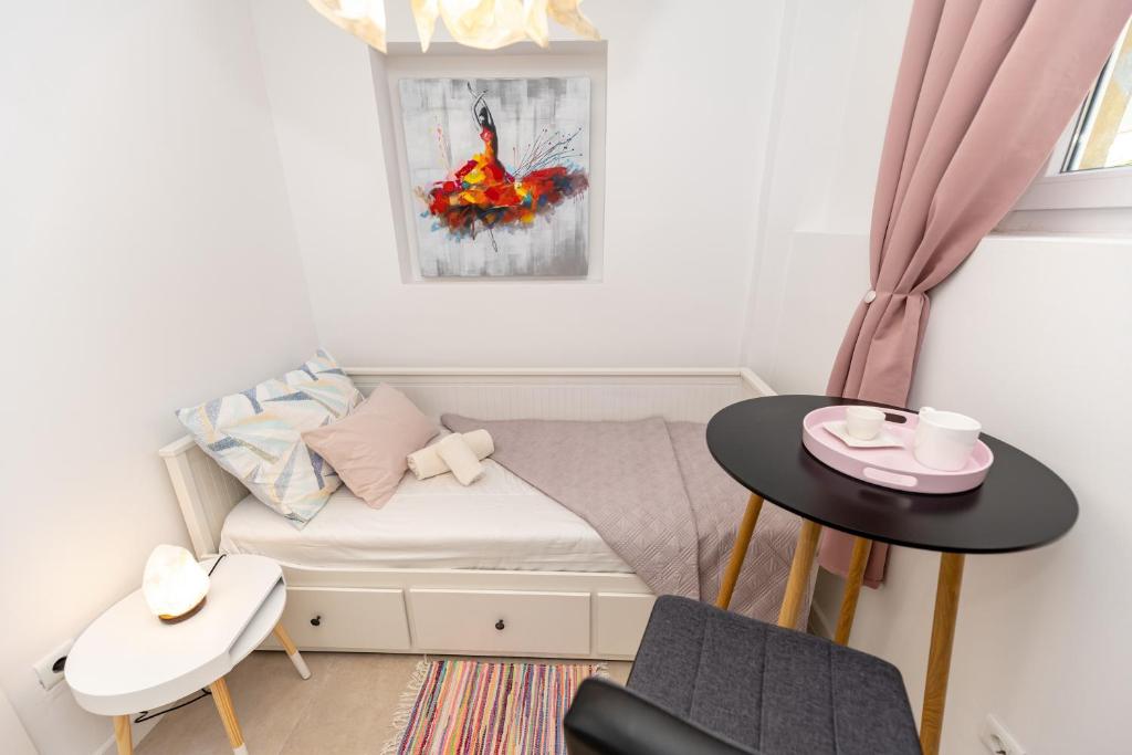um pequeno quarto com uma cama e uma mesa em Luxury rooms Erceg em Zadar