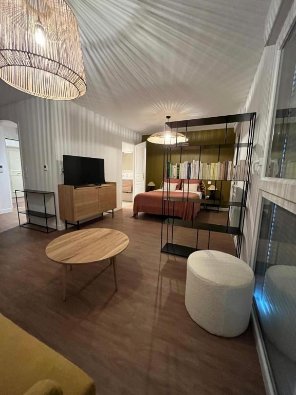 Sala de estar amplia con cama y mesa en RESIDENCE MONTANA, en Cholet