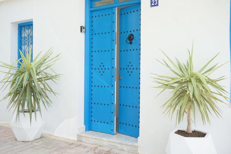 a blue door with two palm trees in front of it at la villa farniente de sidi bou said in Sidi Bou Saïd