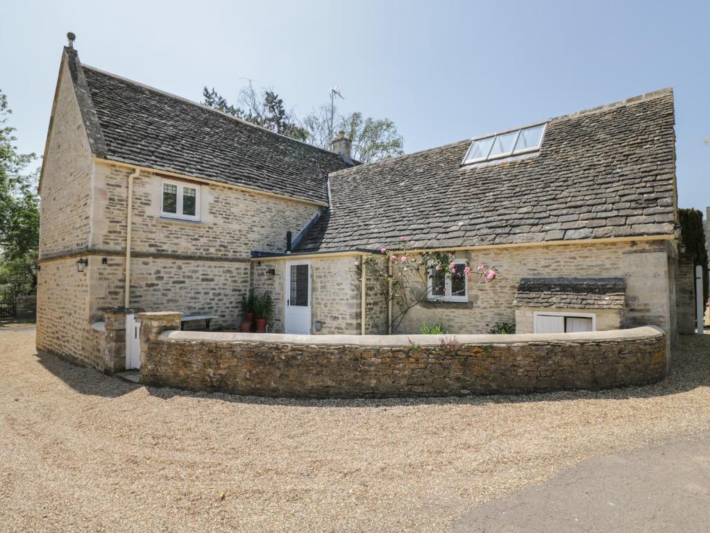 an old stone house with a stone driveway at The Cottage in Malmesbury