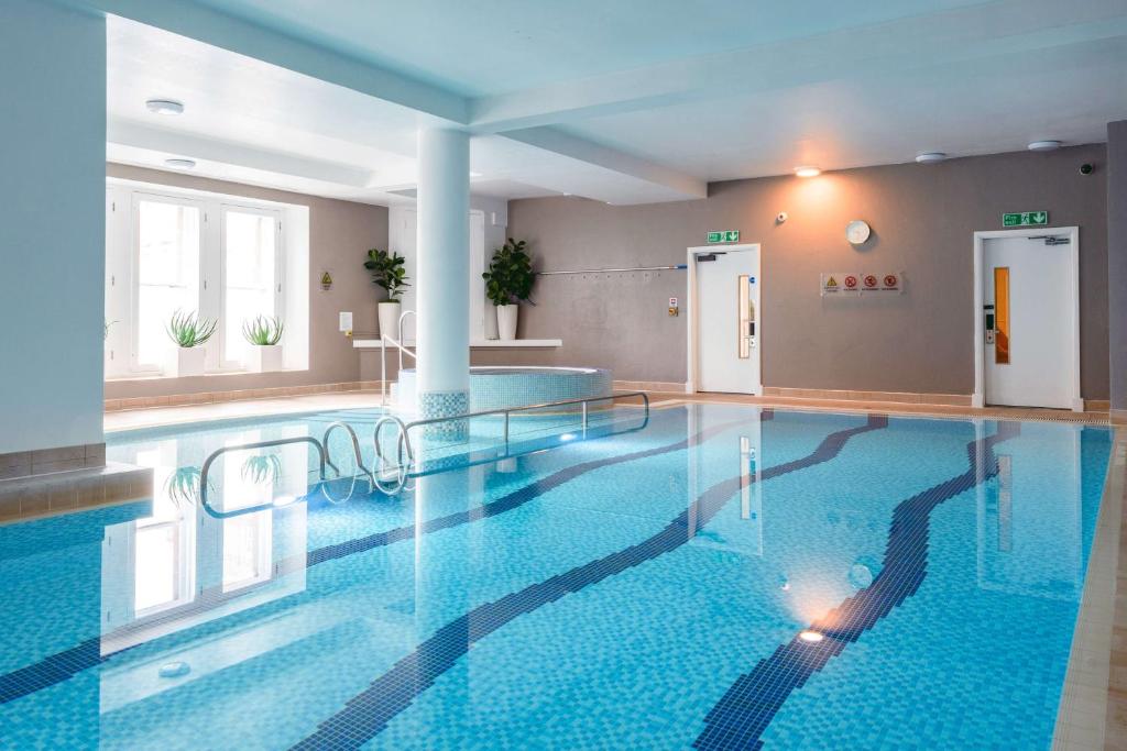 a large swimming pool in a building with a large pool at The Caledonian Edinburgh, Curio Collection by Hilton in Edinburgh