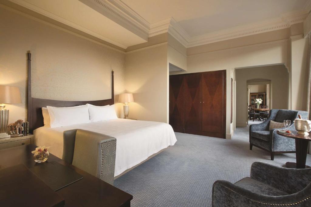 a hotel room with a bed and a desk and chairs at The Caledonian Edinburgh, Curio Collection by Hilton in Edinburgh