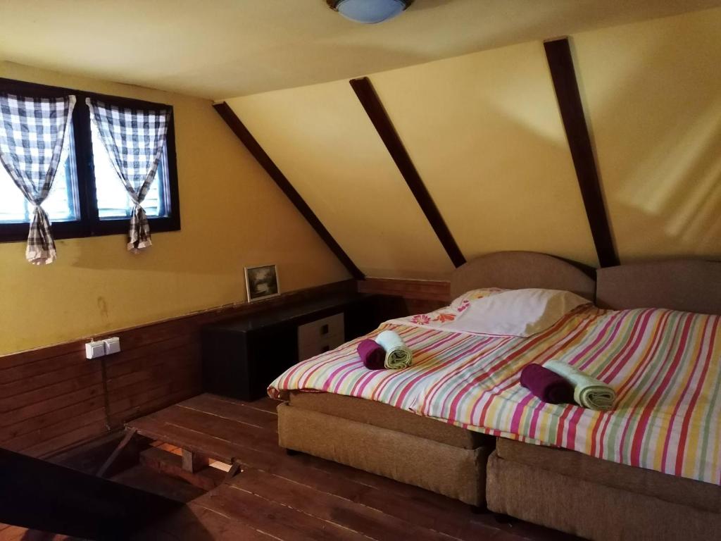 een slaapkamer met een bed en een bank in een kamer bij Vikendica na Drini DRINSKI ODMOR in Crnča