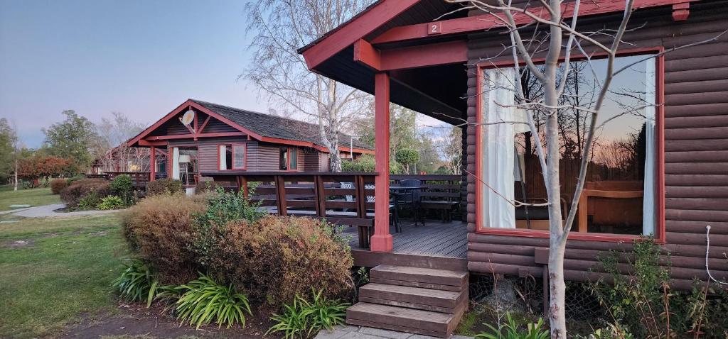 a log cabin with a deck and a table at Hotel y Cabañas Las Mellizas - Caja Los Andes in Los Ángeles