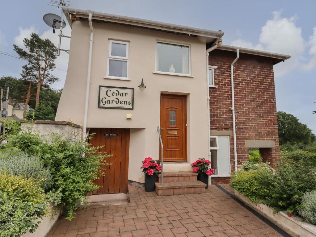 una casa con una señal que lee esturiones de color en Cedar Gardens en Llabedr-Dyffryn-Clwyd