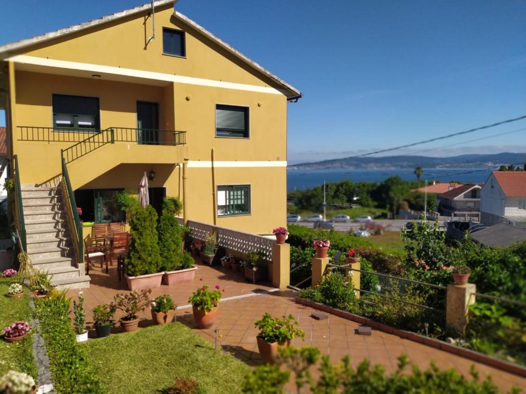 a yellow house with a balcony and a yard at A casa da Piruleta in Bueu