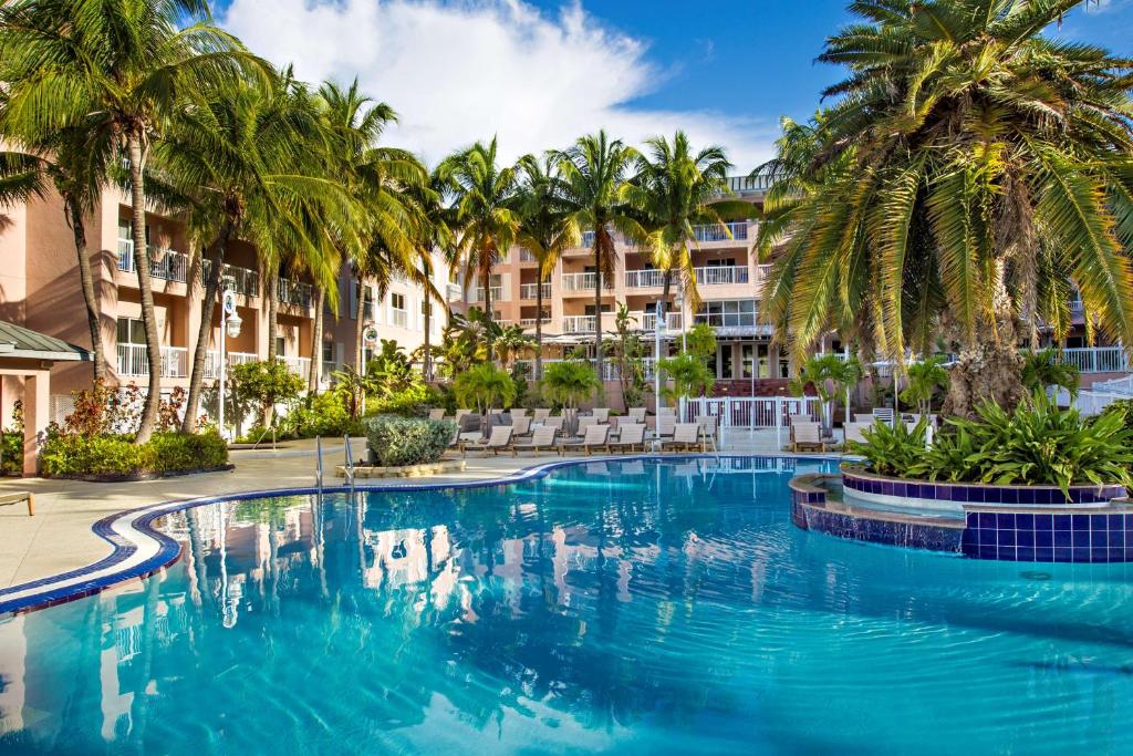 a swimming pool with palm trees in front of a building at DoubleTree by Hilton Grand Key Resort in Key West