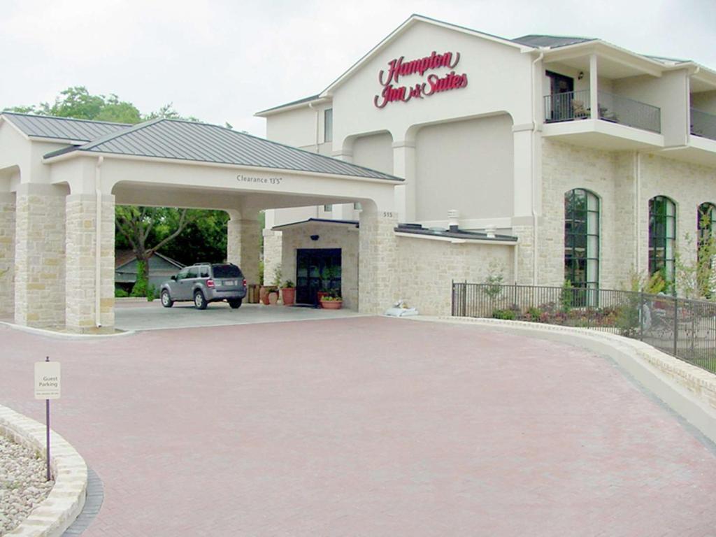 a building with a car parked in front of it at Hampton Inn & Suites Fredericksburg in Fredericksburg