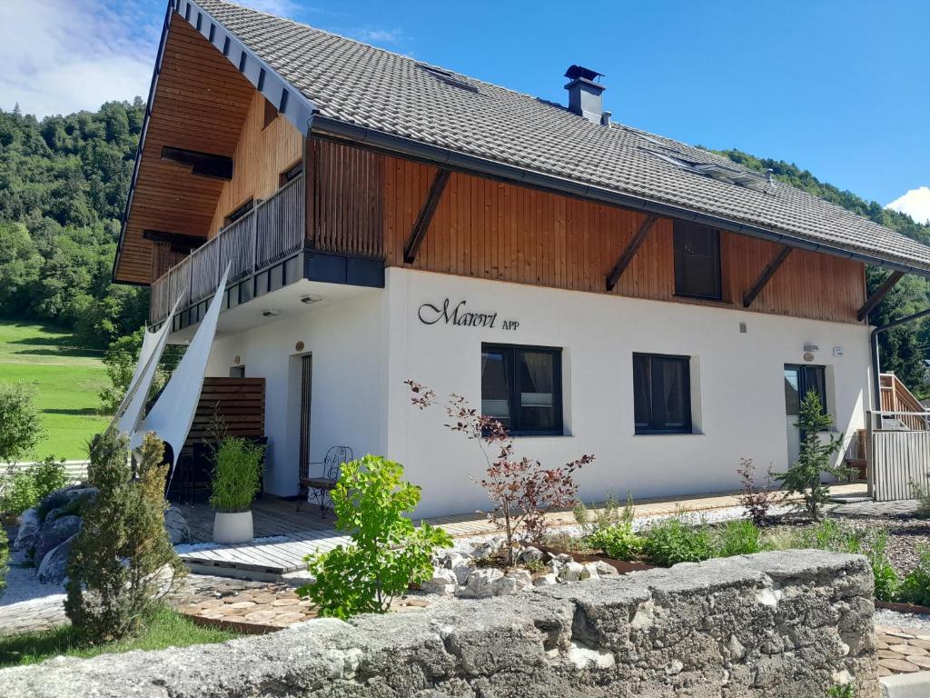 ein Haus in den Bergen mit einer Steinmauer in der Unterkunft Marovt App in Bled