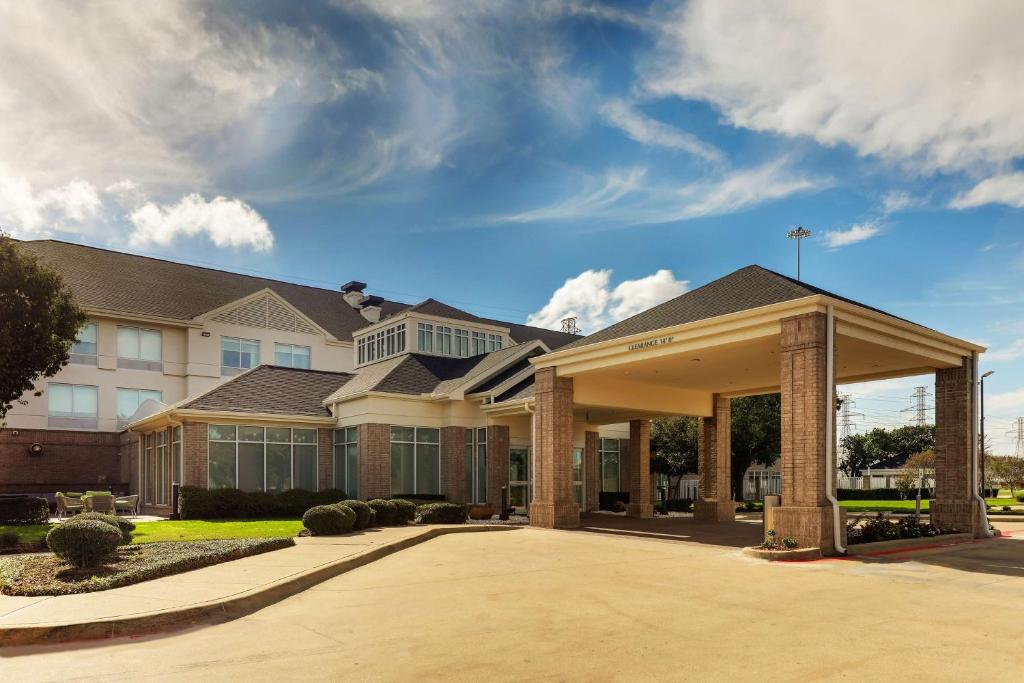 a large house with a driveway in front of it at Hilton Garden Inn Fort Worth/Fossil Creek in Fort Worth